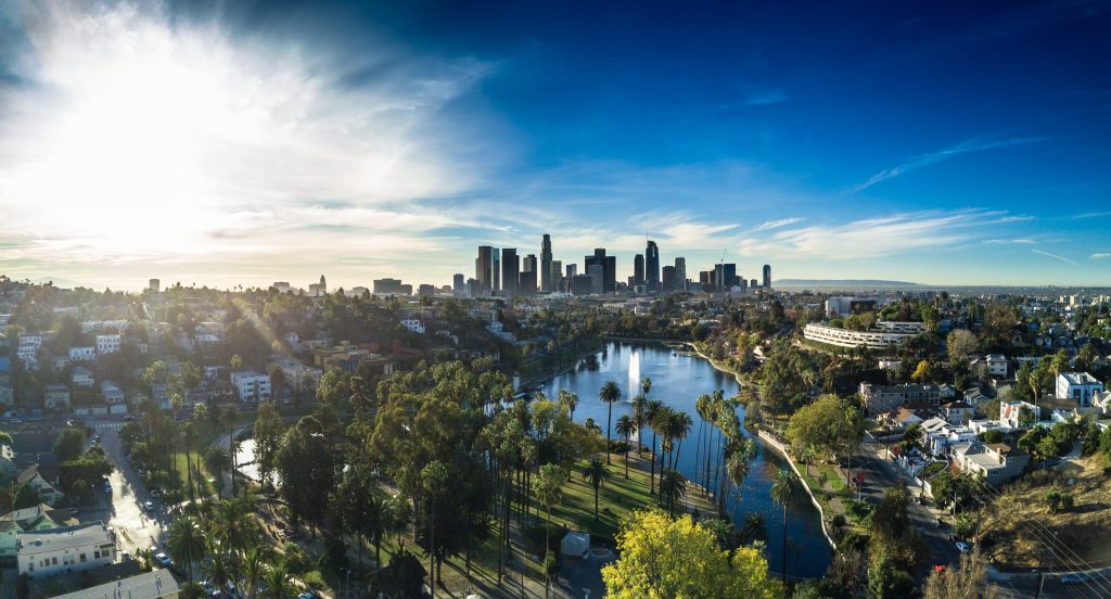 Aerial view of Los Angeles including trees and lake on sunny day.