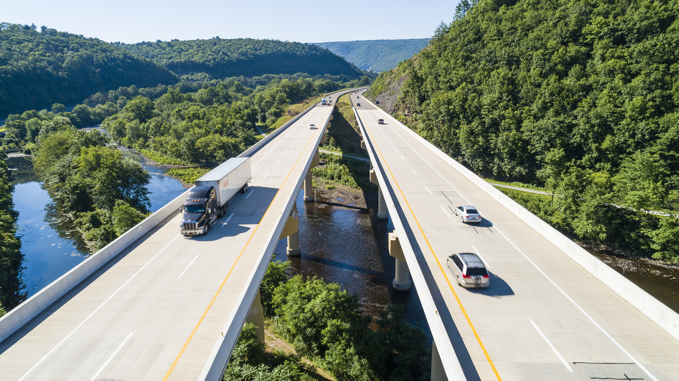 Transportation impacts due to trucks and cars travelling through mountains on bridge spanning river