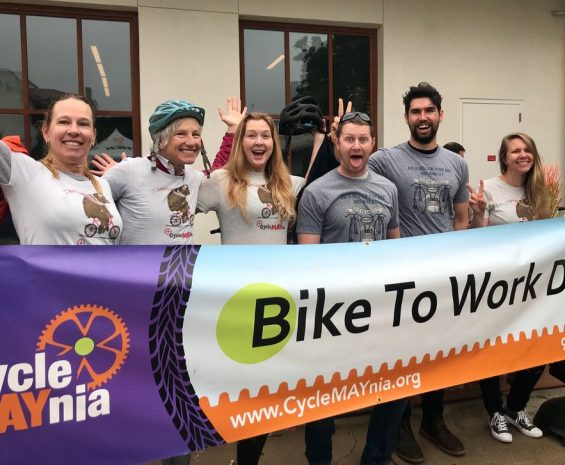 GrDudek staff pose behind Bike to Work Day banner
