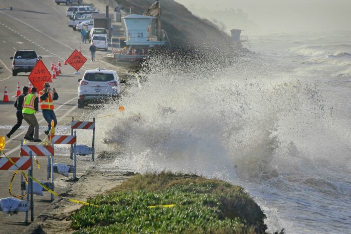 A wave splashes onto the roadway in San Diego, a risk evaluated in SANDAG's sea-level rise assessment.