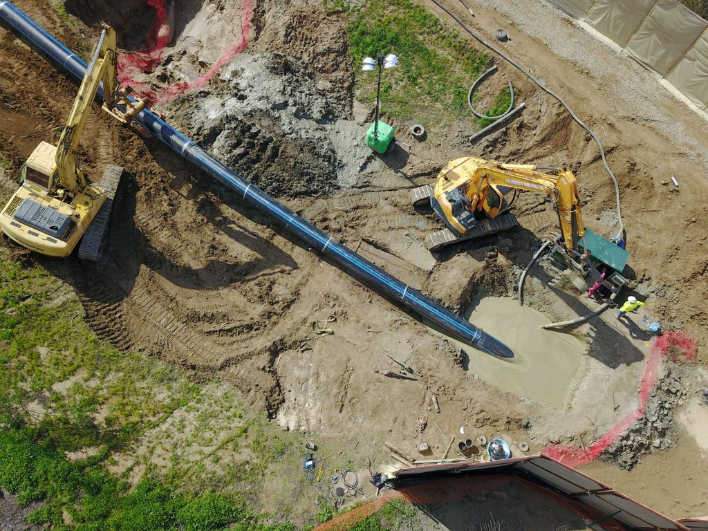 Dudek project site. Aerial view as cranes install the Chino Basin Desalter Authority's Product Water Pipeline using horizontal directional drilling crossing the Santa Ana River.